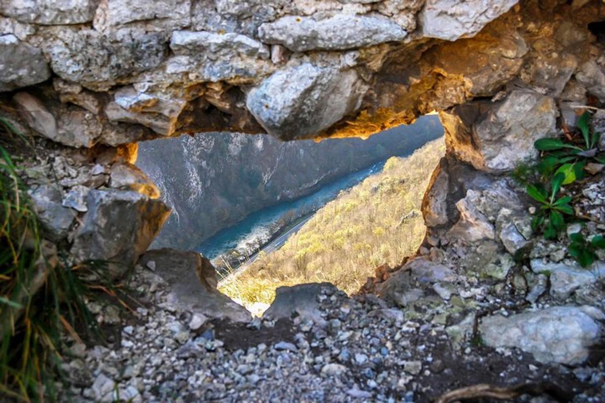 a view of a river through a stone wall