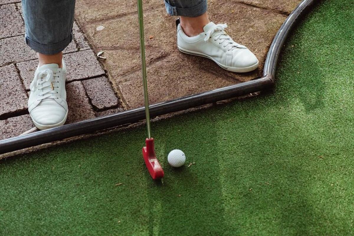 seorang yang memakai kasut putih bermain golf