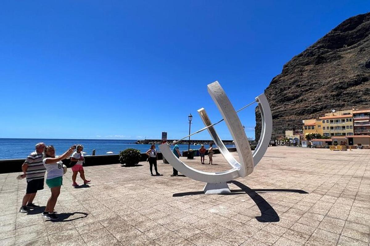 Un grupo de personas tomando fotografías de una escultura en la playa.