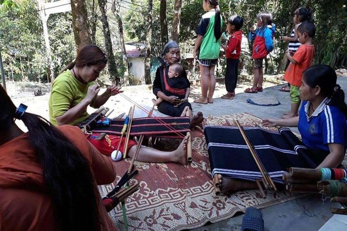 um grupo de pessoas em pé ao redor de uma mulher segurando um bebê