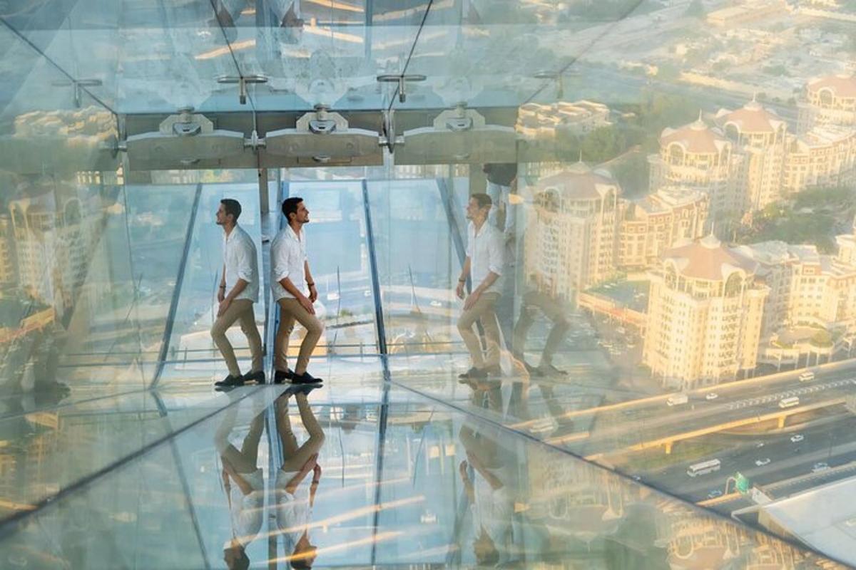 a group of people walking on a glass floor in a building