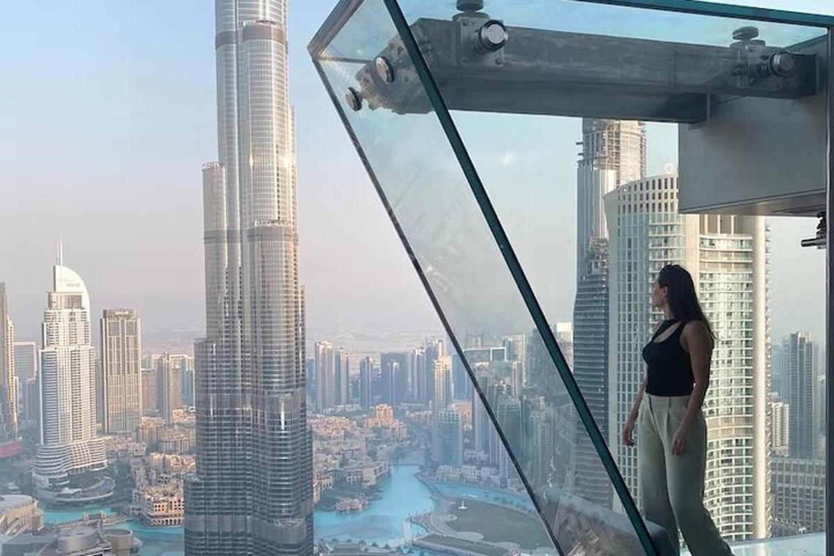 a woman standing on the top of a skyscraper