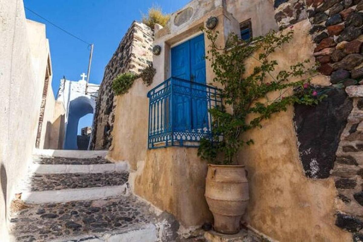 ένα κτίριο με μια μπλε πόρτα και ένα φυτό σε γλάστρα