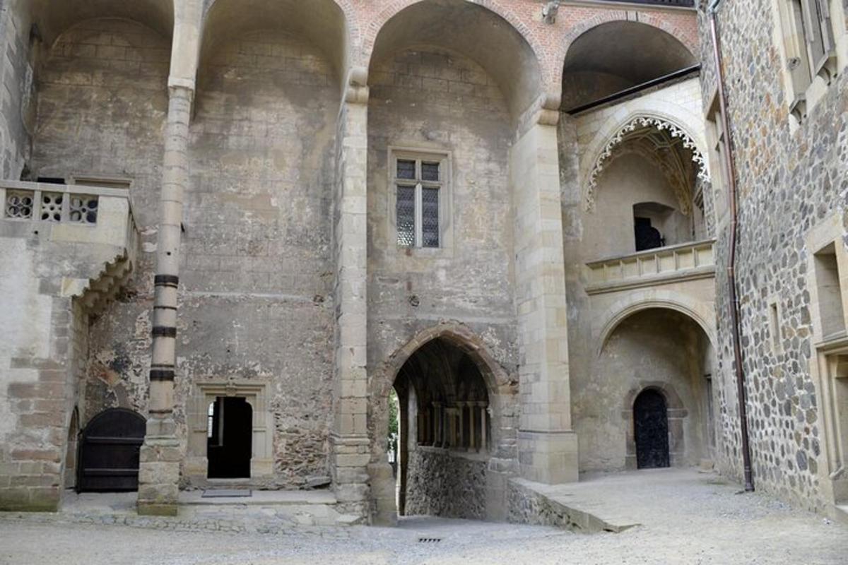 Un gran edificio de piedra con arcos a los lados.