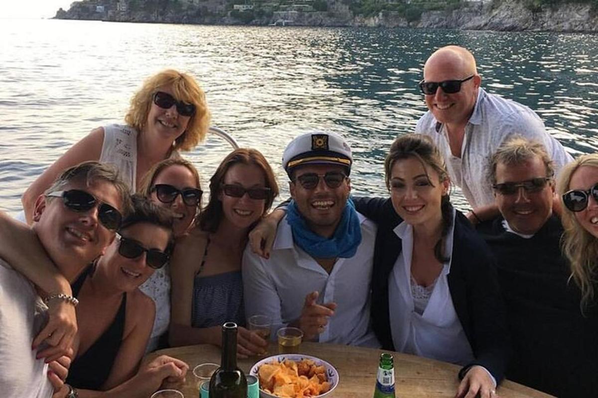μια ομάδα ανθρώπων που ποζάρουν για μια φωτογραφία σε μια βάρκα
