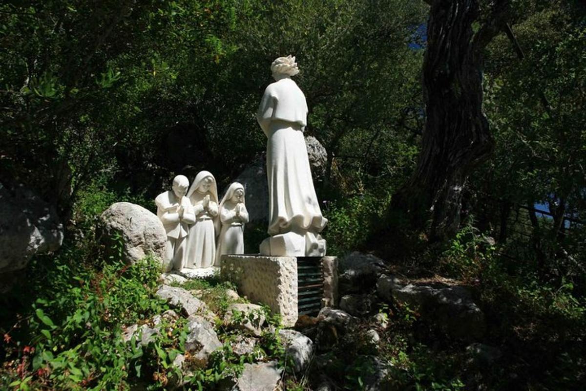 ένα άγαλμα μιας γυναίκας και τριών μοναχών σε ένα πάρκο
