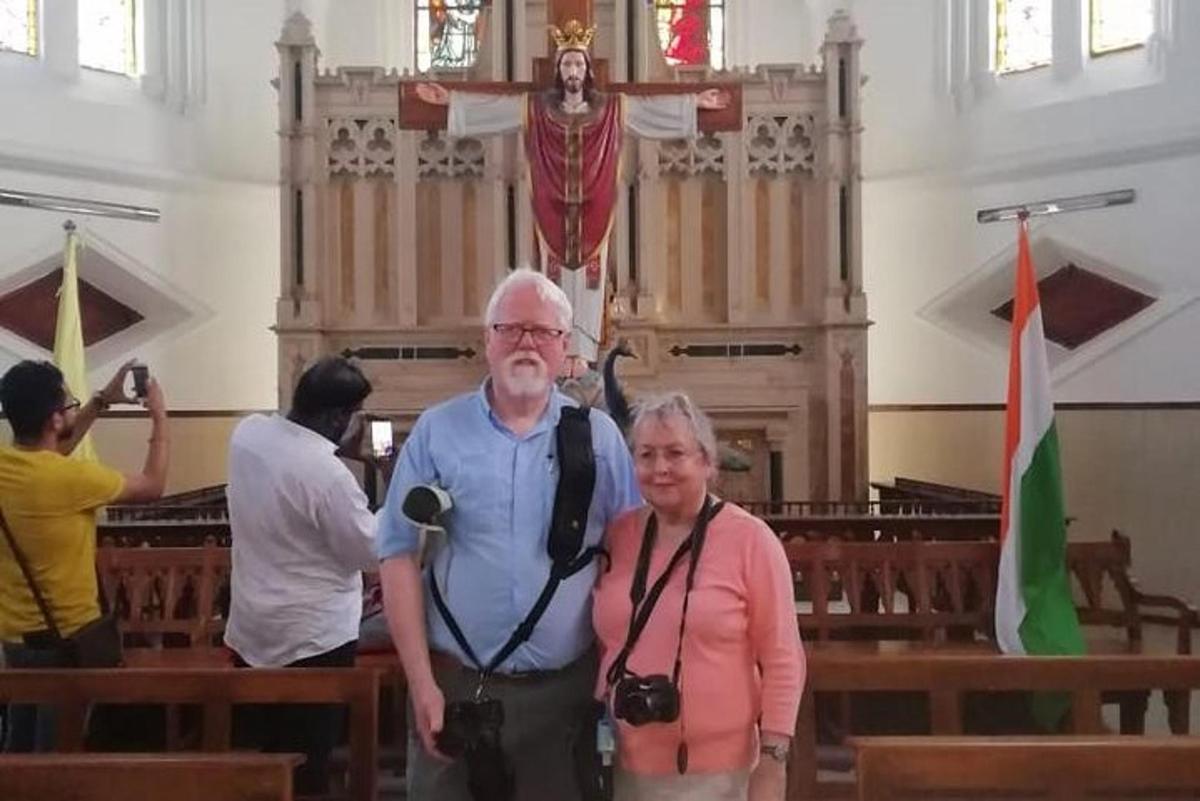 a man and a woman standing in front of a church