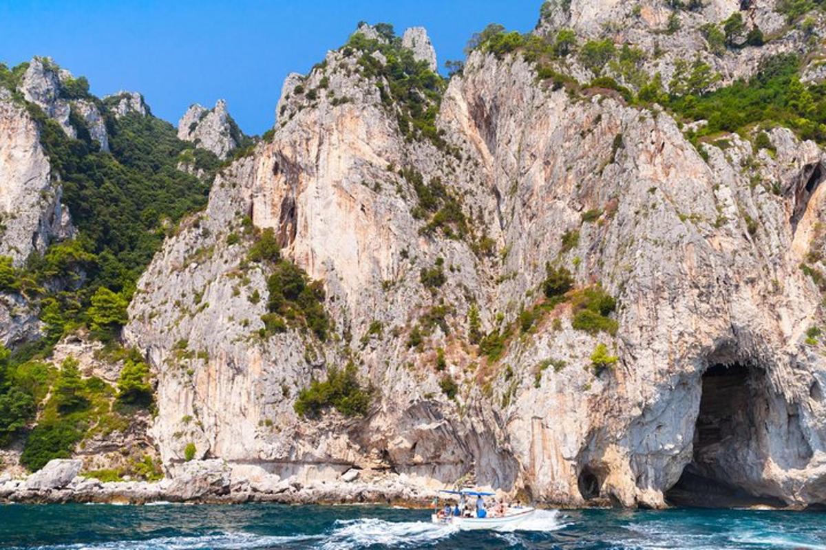 μια βάρκα στο νερό κοντά σε ένα βραχώδες βουνό
