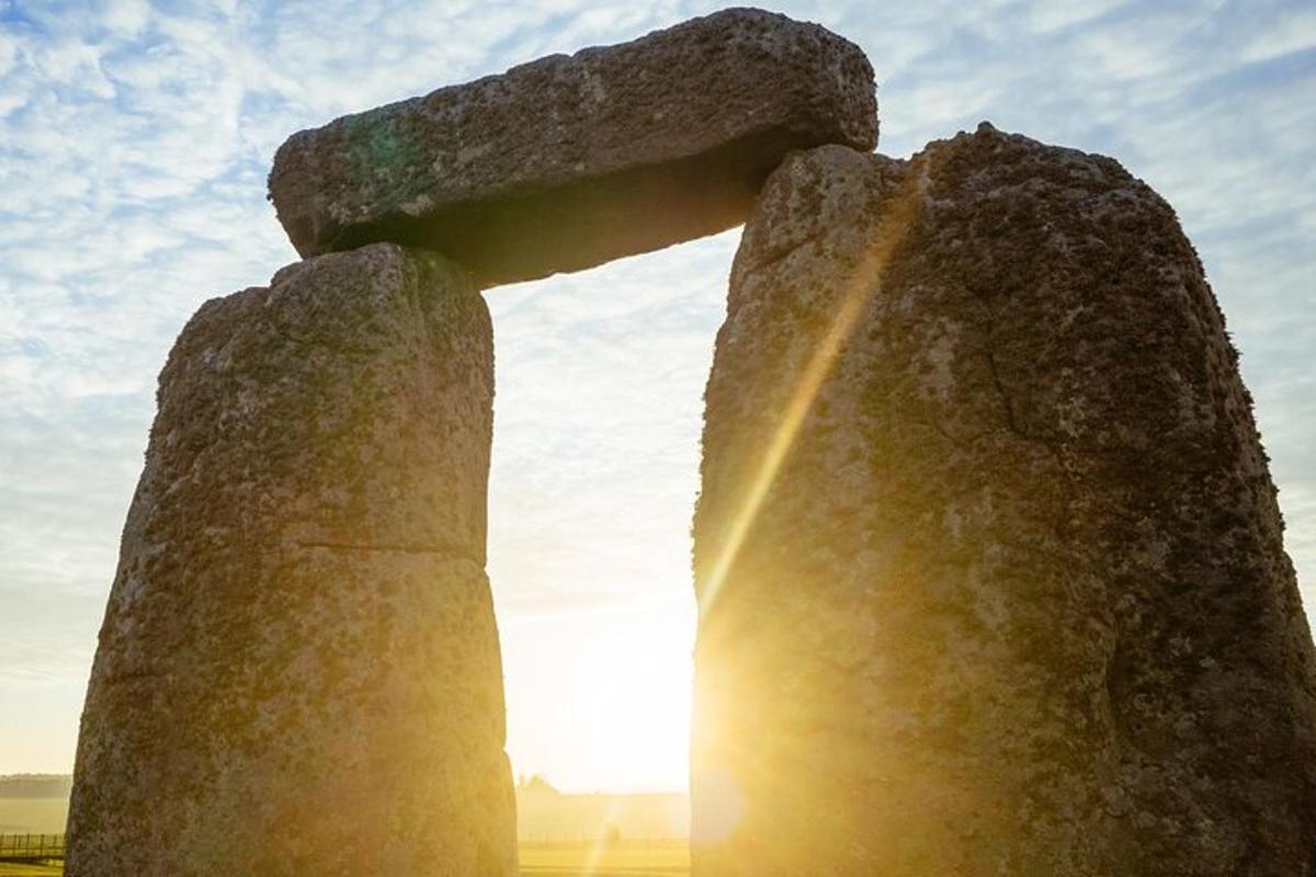 una statua di una croce con il sole dietro