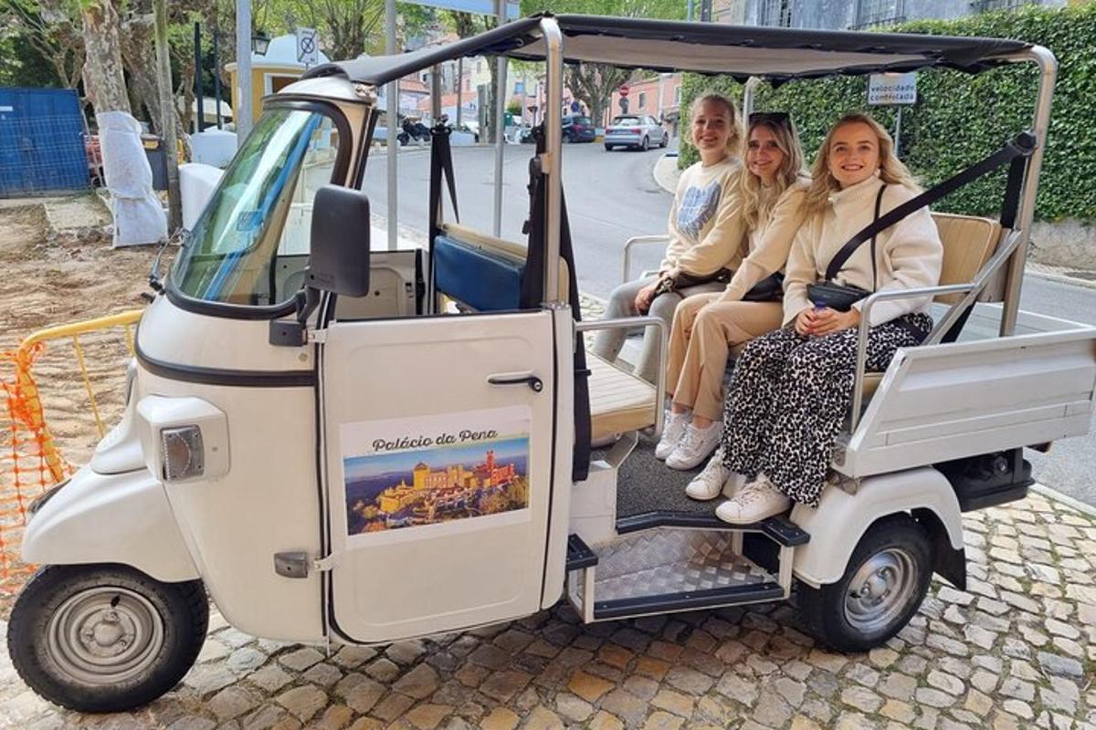 skupina ljudi, ki sedijo v golfskem vozičku