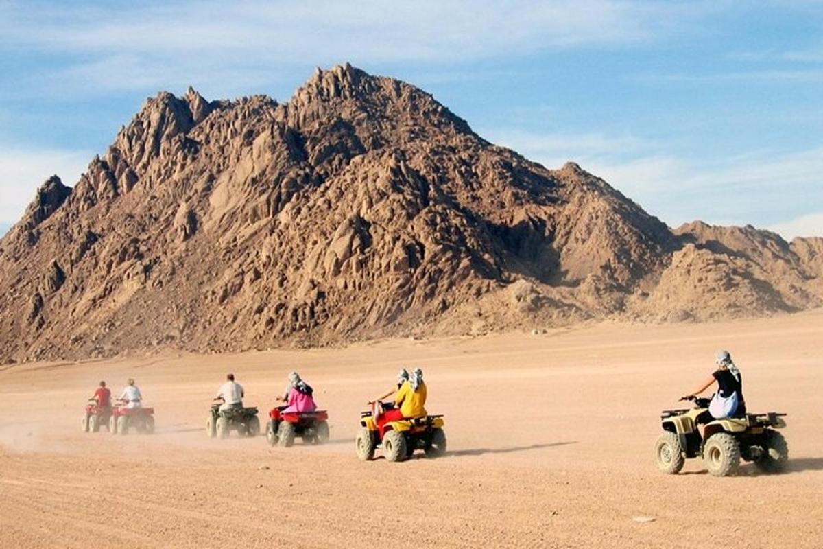 un gruppo di persone che guidano quad nel deserto