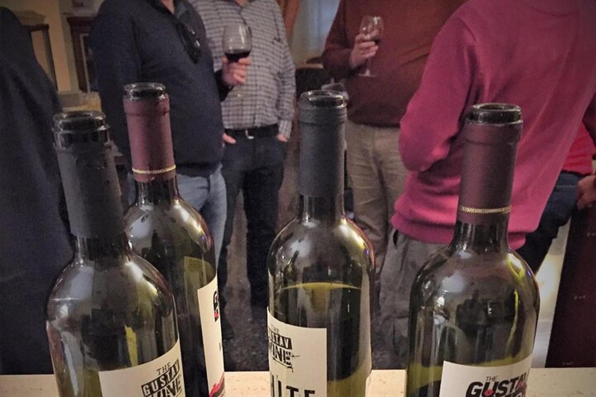 a group of people standing around three bottles of wine