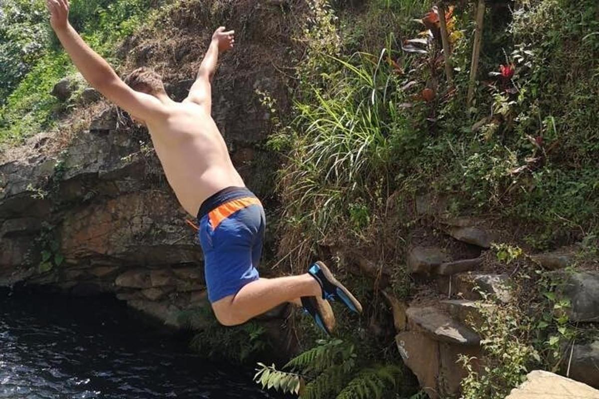 seorang lelaki melompat dari tebing ke dalam badan air