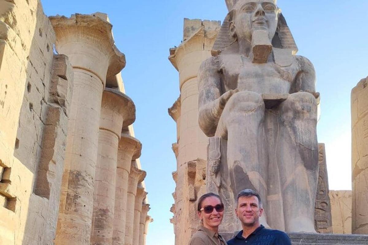 two people standing in front of a statue