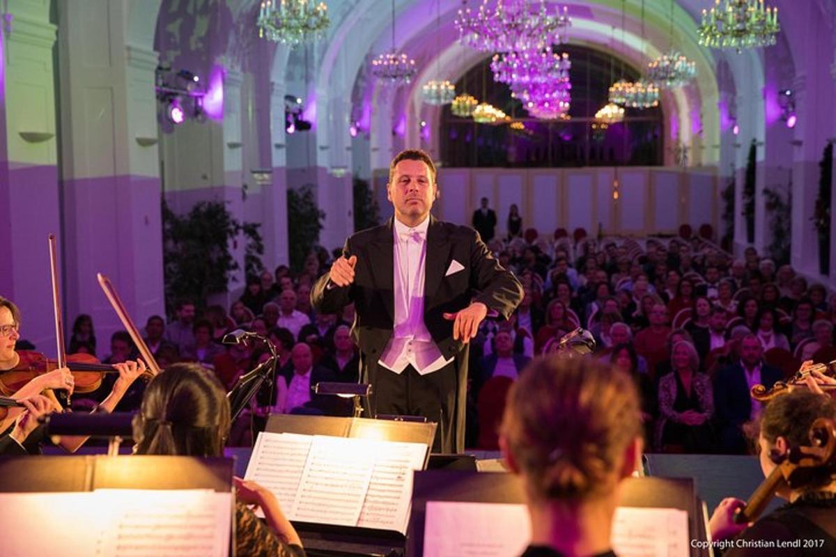 muž v obleku stojící před orchestrem