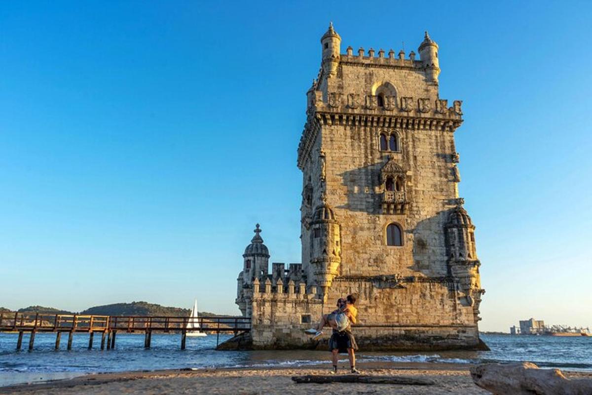 una persona parada en la playa frente a una torre en el agua