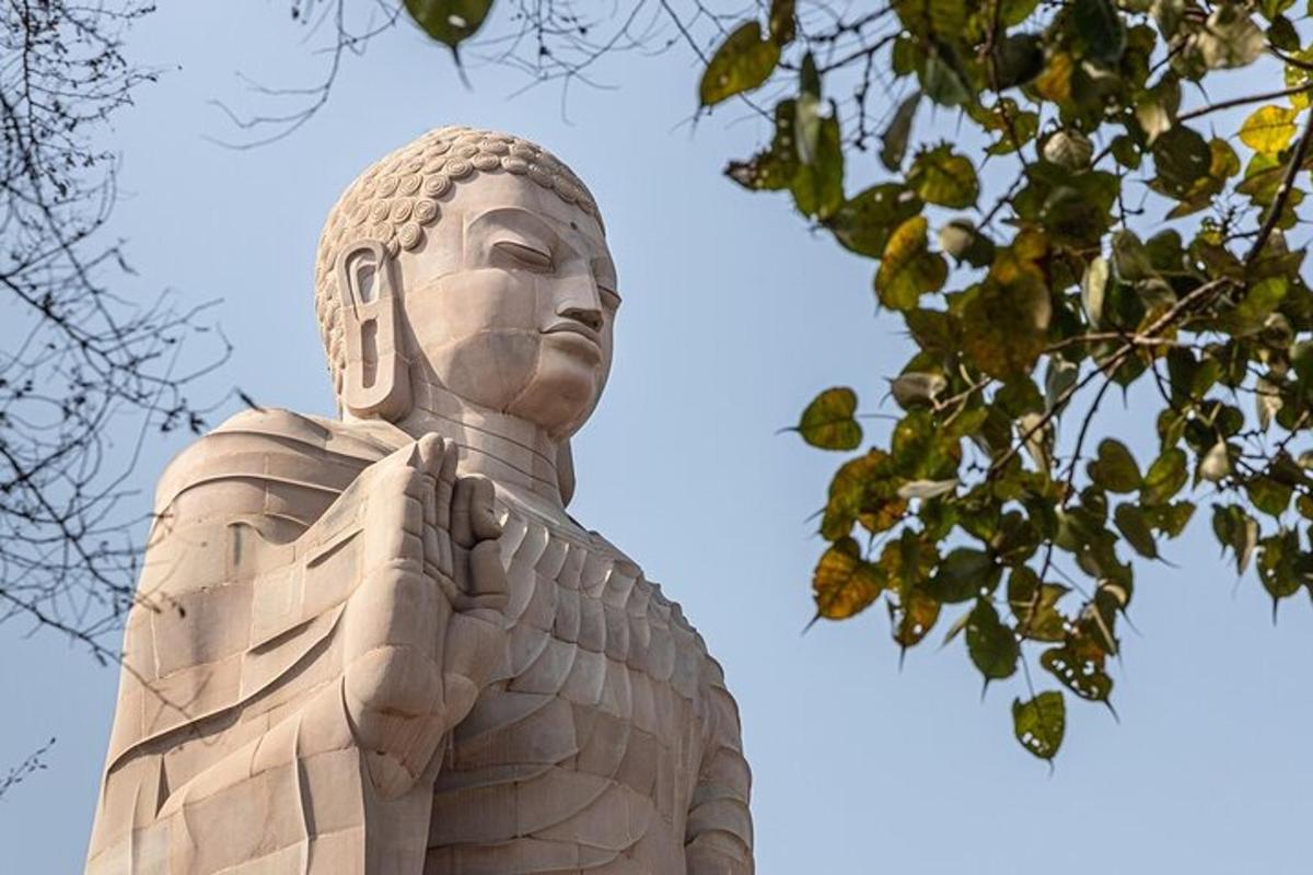 a statue of a woman standing next to a tree