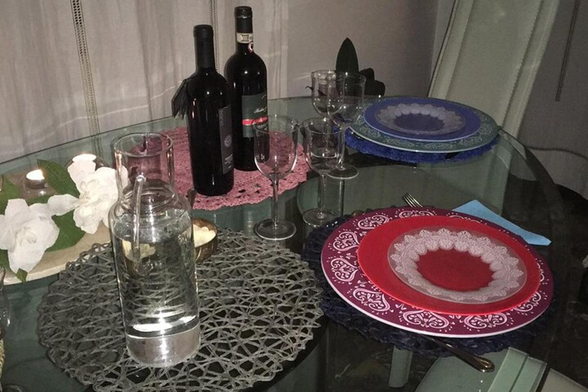 uma mesa de vidro com garrafas de vinho e um prato vermelho