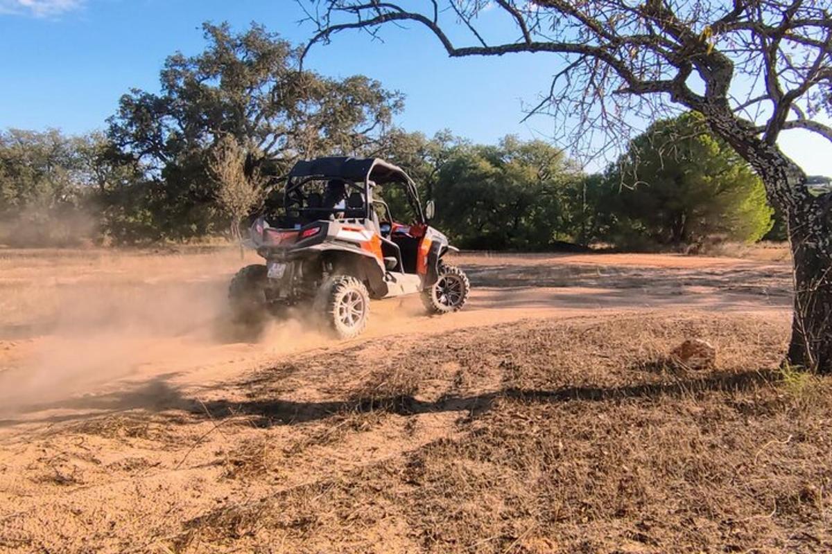 o persoană care merge cu un ATV pe un drum de pământ