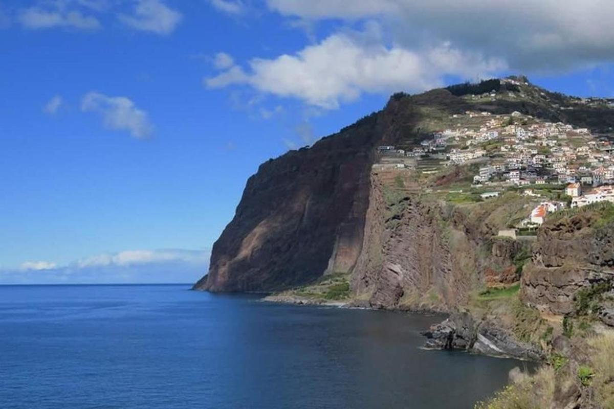 una montagna con case in cima vicino all'acqua