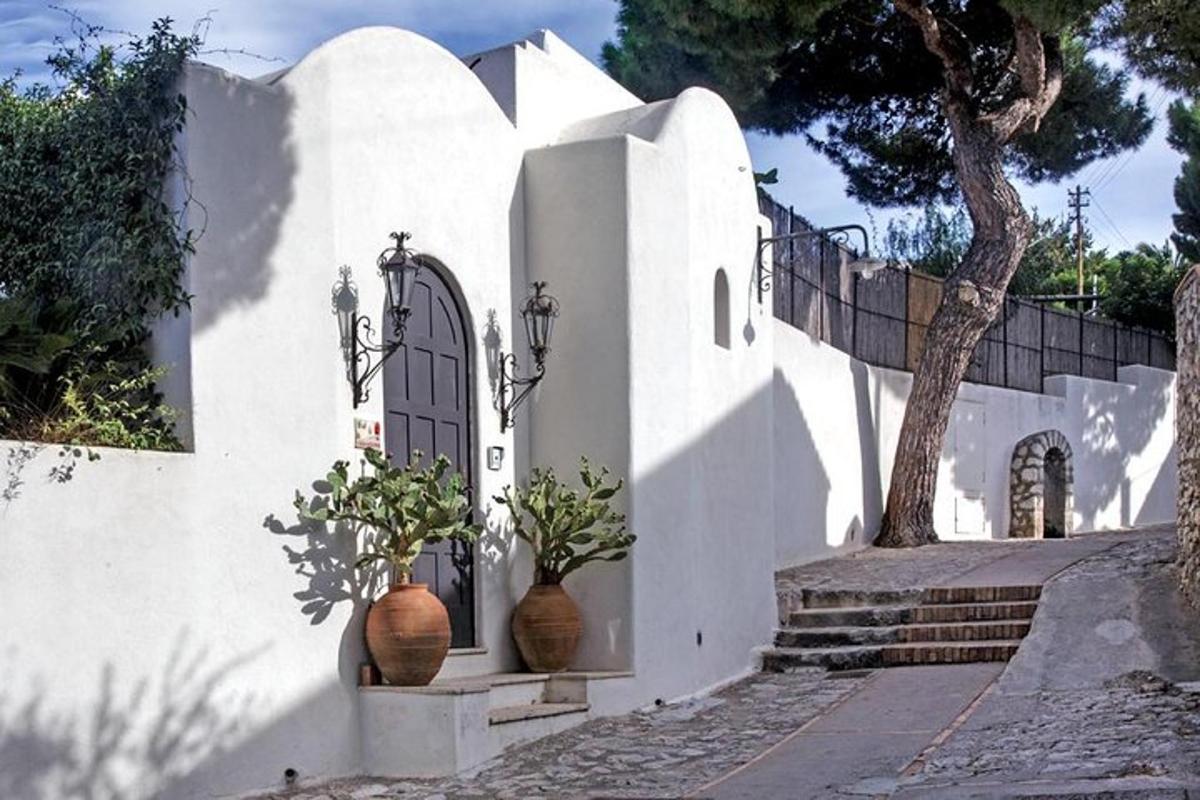 una casa blanca con dos jarrones y una puerta