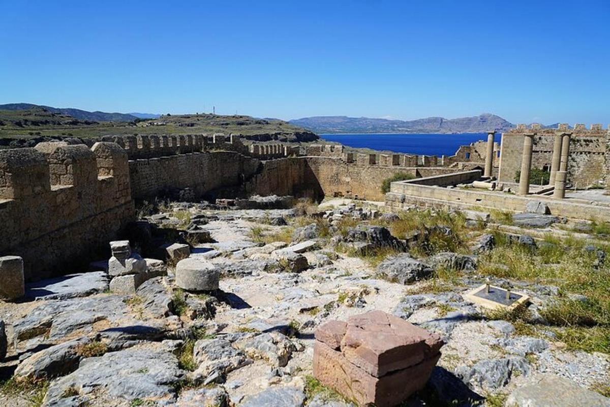 an ancient ruins with a body of water in the background
