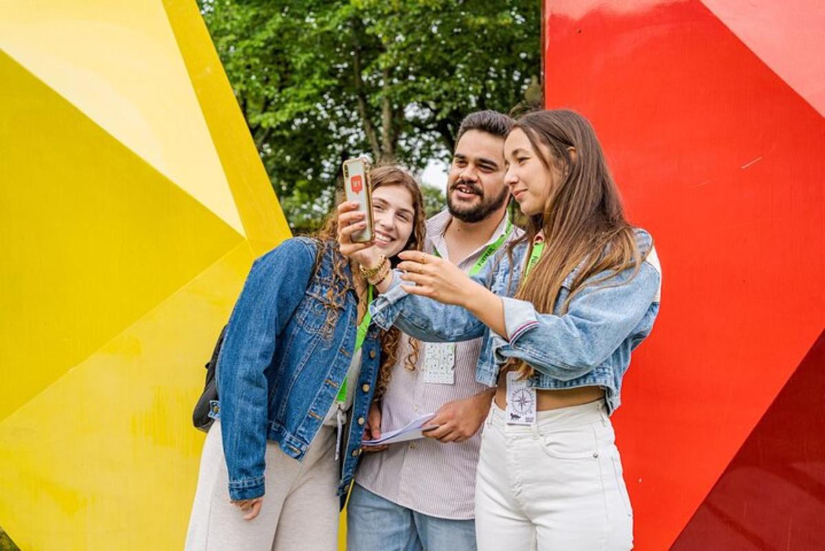 skupina tří lidí, kteří si fotí mobilním telefonem