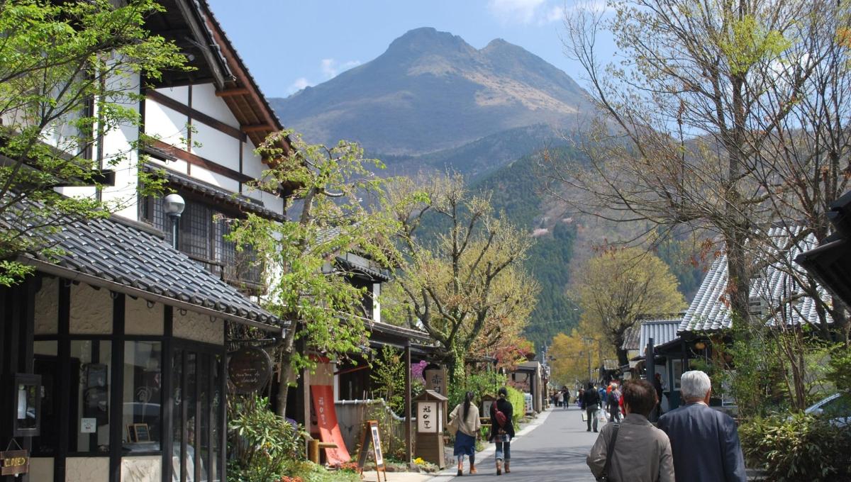 a group of people walking down a street with a mountain