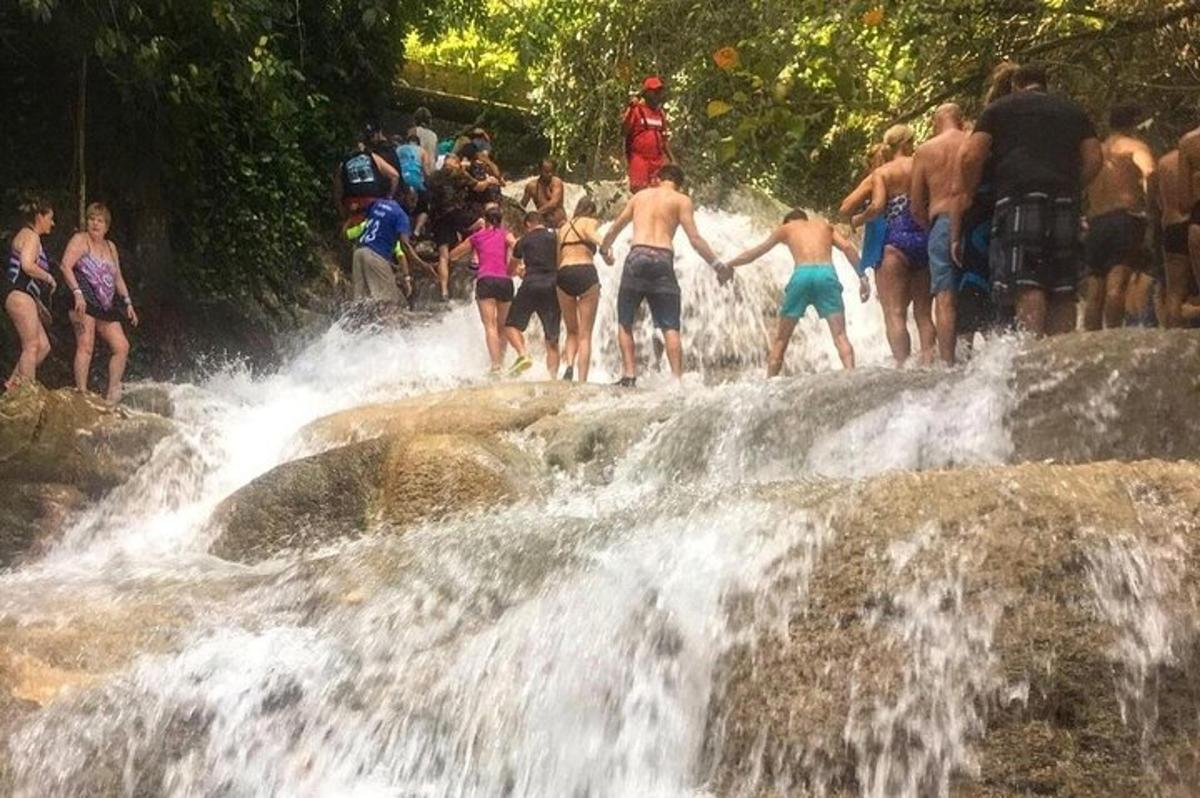 um grupo de pessoas em pé no topo de uma cachoeira