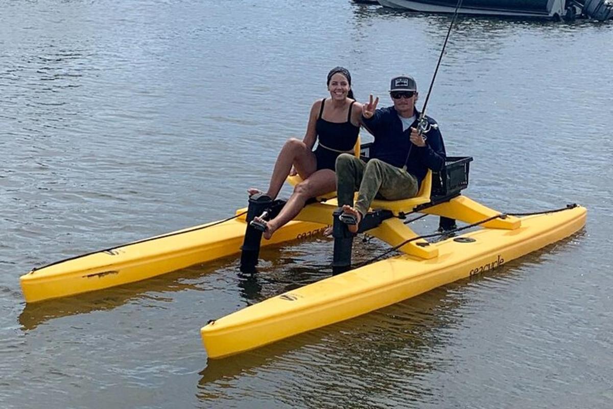 a man and a woman sitting on a yellow kayak
