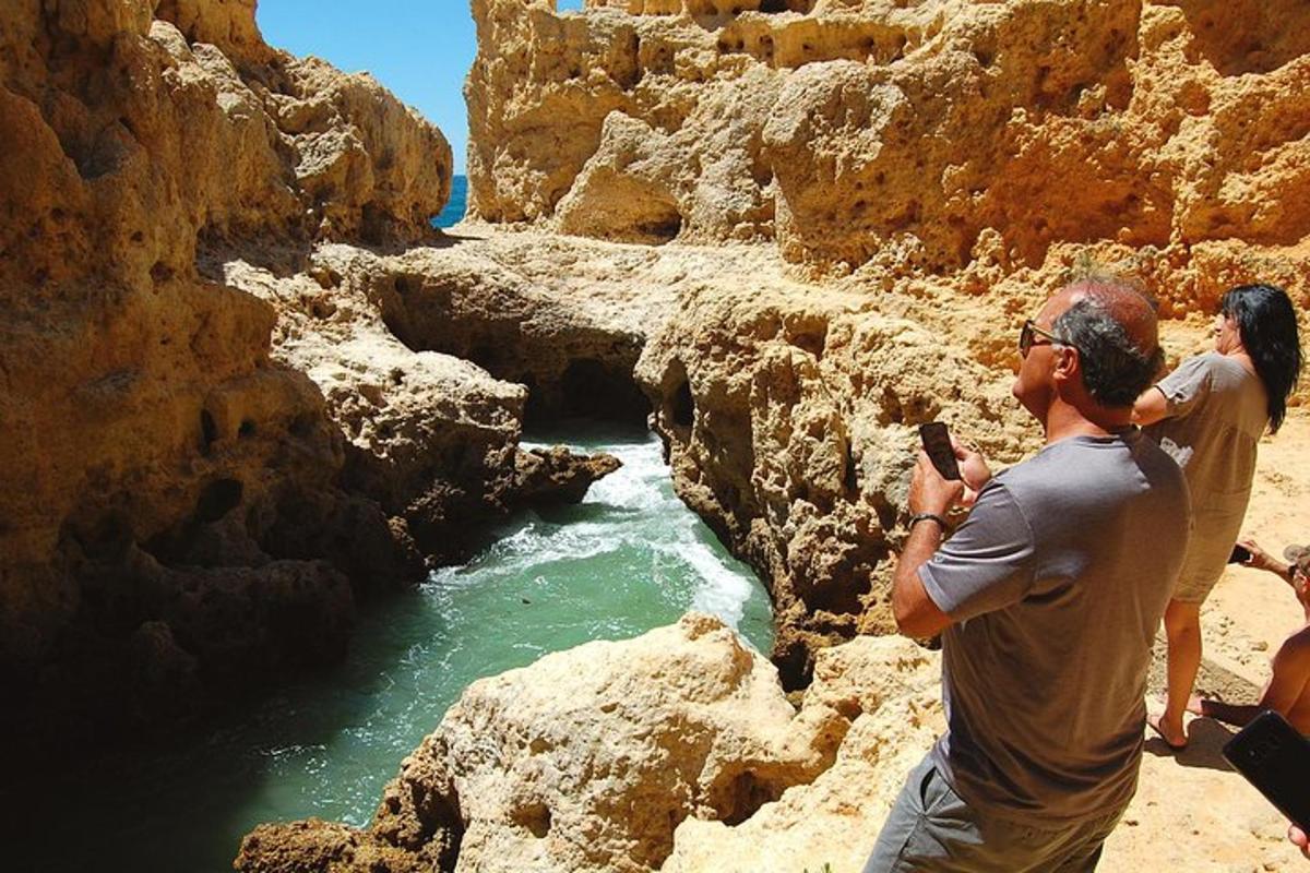 Un hombre tomando una fotografía de un río con su teléfono celular.