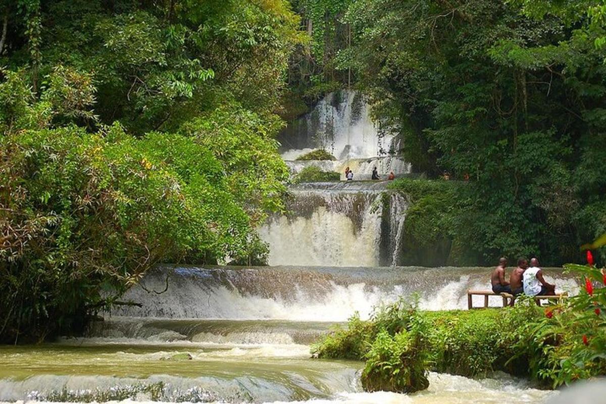 persone sedute su una panchina davanti a una cascata