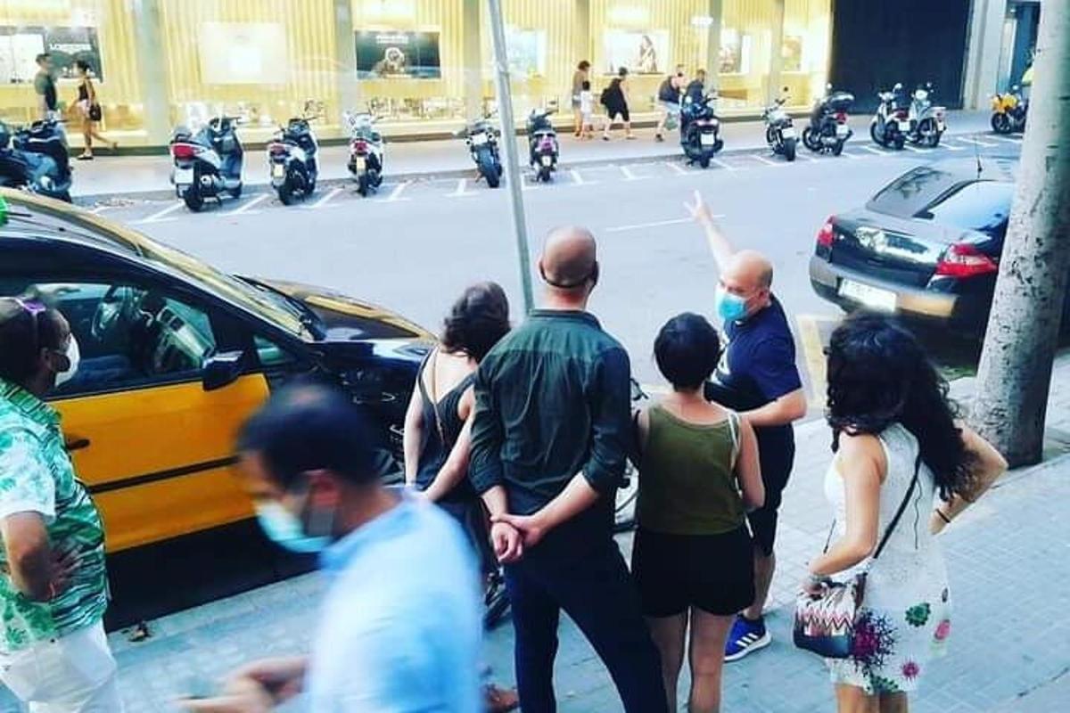 un gruppo di persone che indossano maschere facciali in piedi su una strada