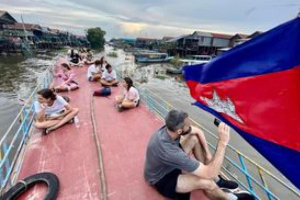 Un grupo de personas sentadas en un barco con una bandera.