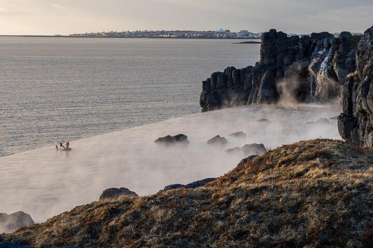 to personer som står på en strand nær vannet