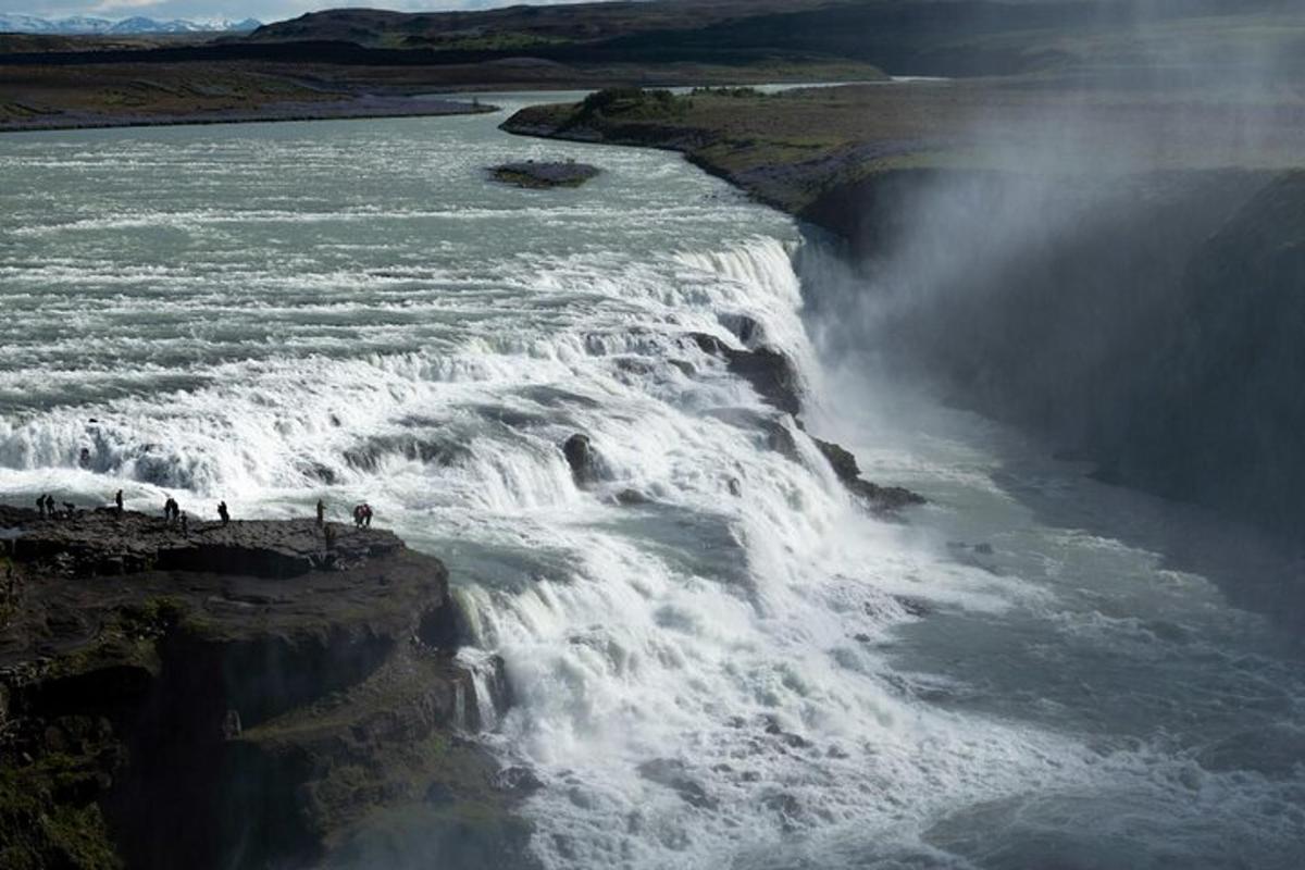 un gruppo di persone in piedi sul bordo di una cascata