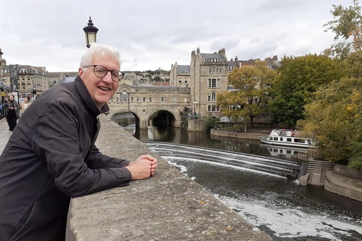 Ein älterer Mann sitzt auf einer Brücke über einem Fluss