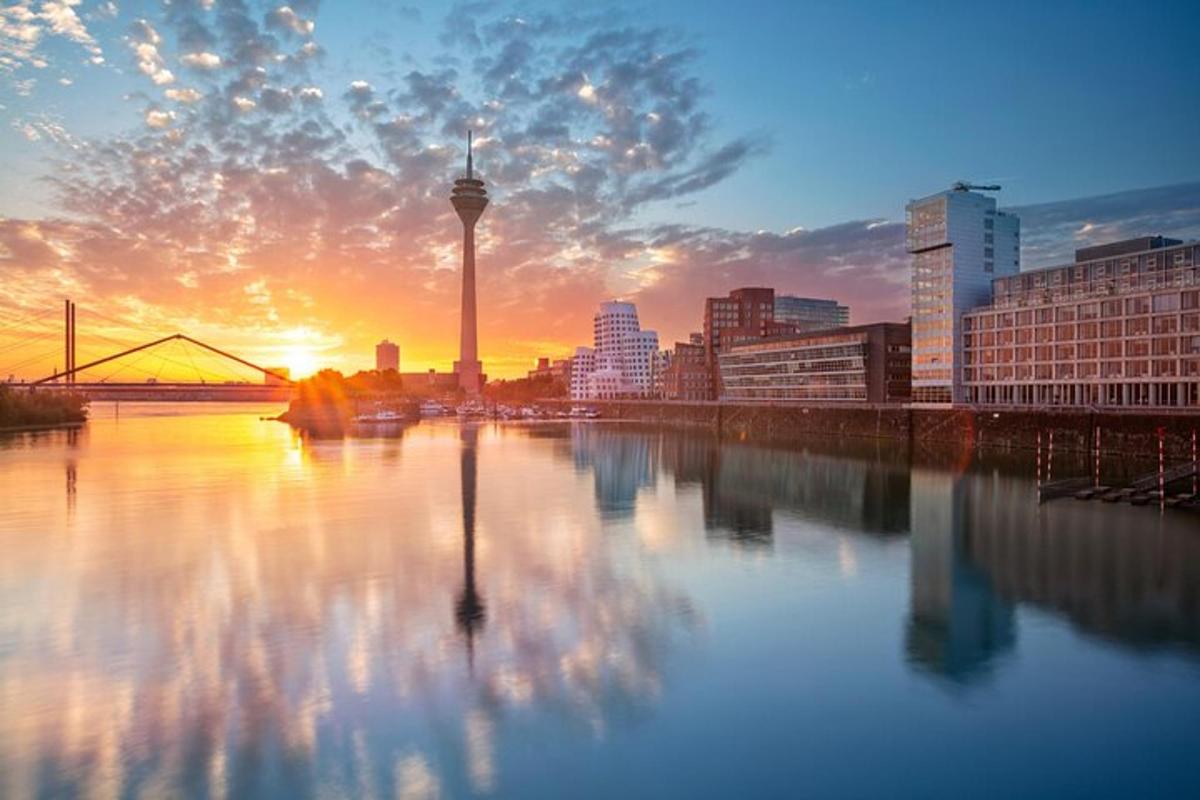 ein Sonnenuntergang über einem Fluss mit einer Stadt im Hintergrund
