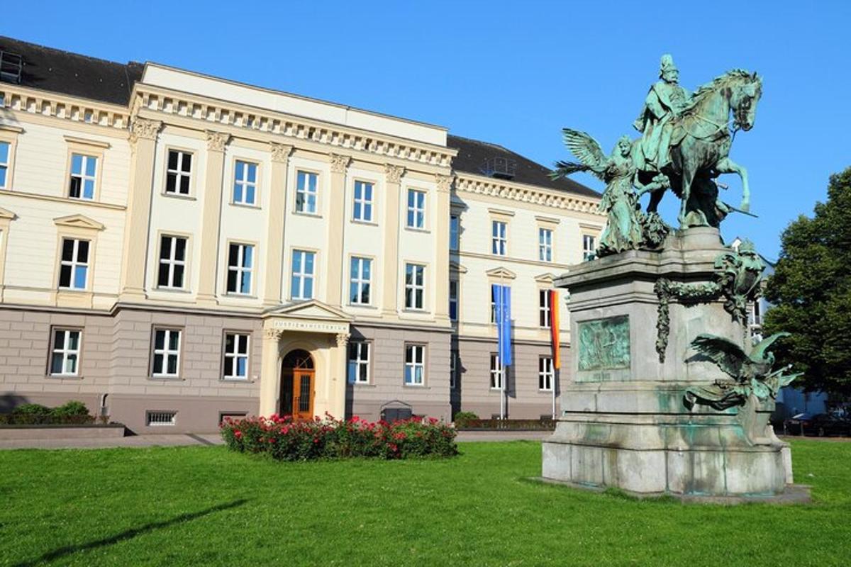 eine Statue im Gras vor einem Gebäude