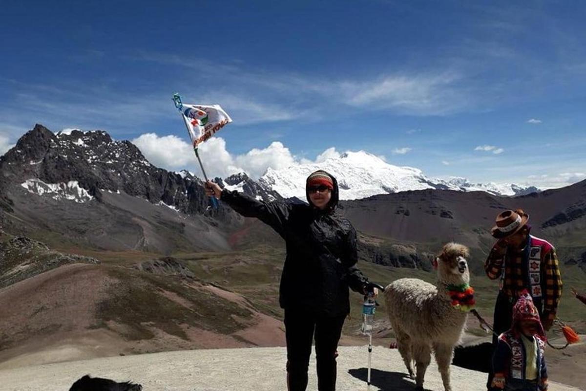 seorang wanita berdiri di atas gunung sambil memegang layang-layang