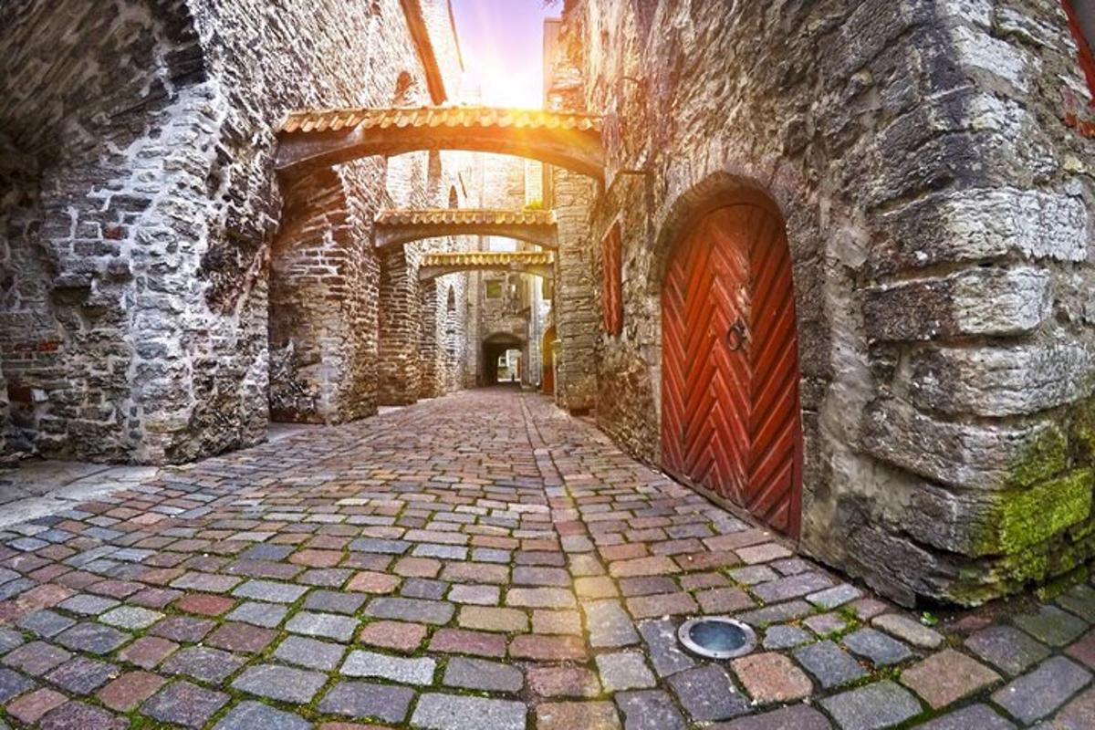 un carreró amb un edifici de pedra amb una porta vermella