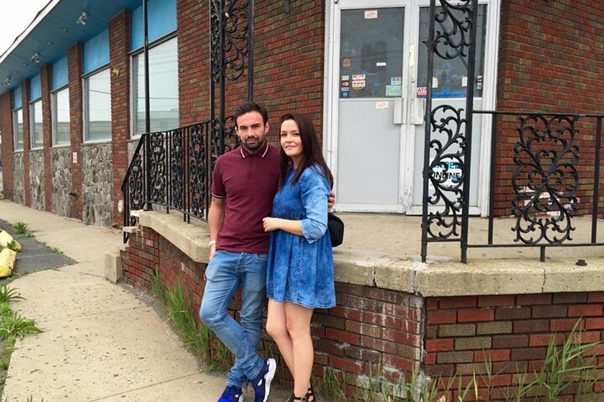 a man and a woman standing next to a brick wall
