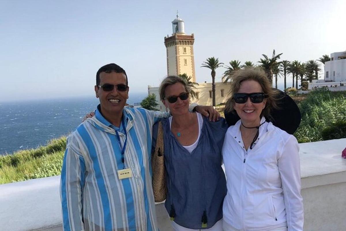 tre persone posano per una foto davanti a un faro