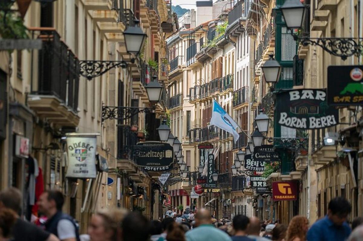 una multitud de gent caminant per un carrer amb edificis