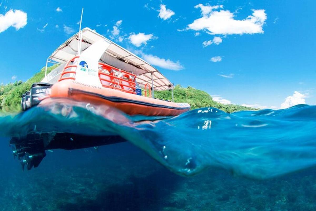 una persona che nuota nell'oceano accanto a una barca