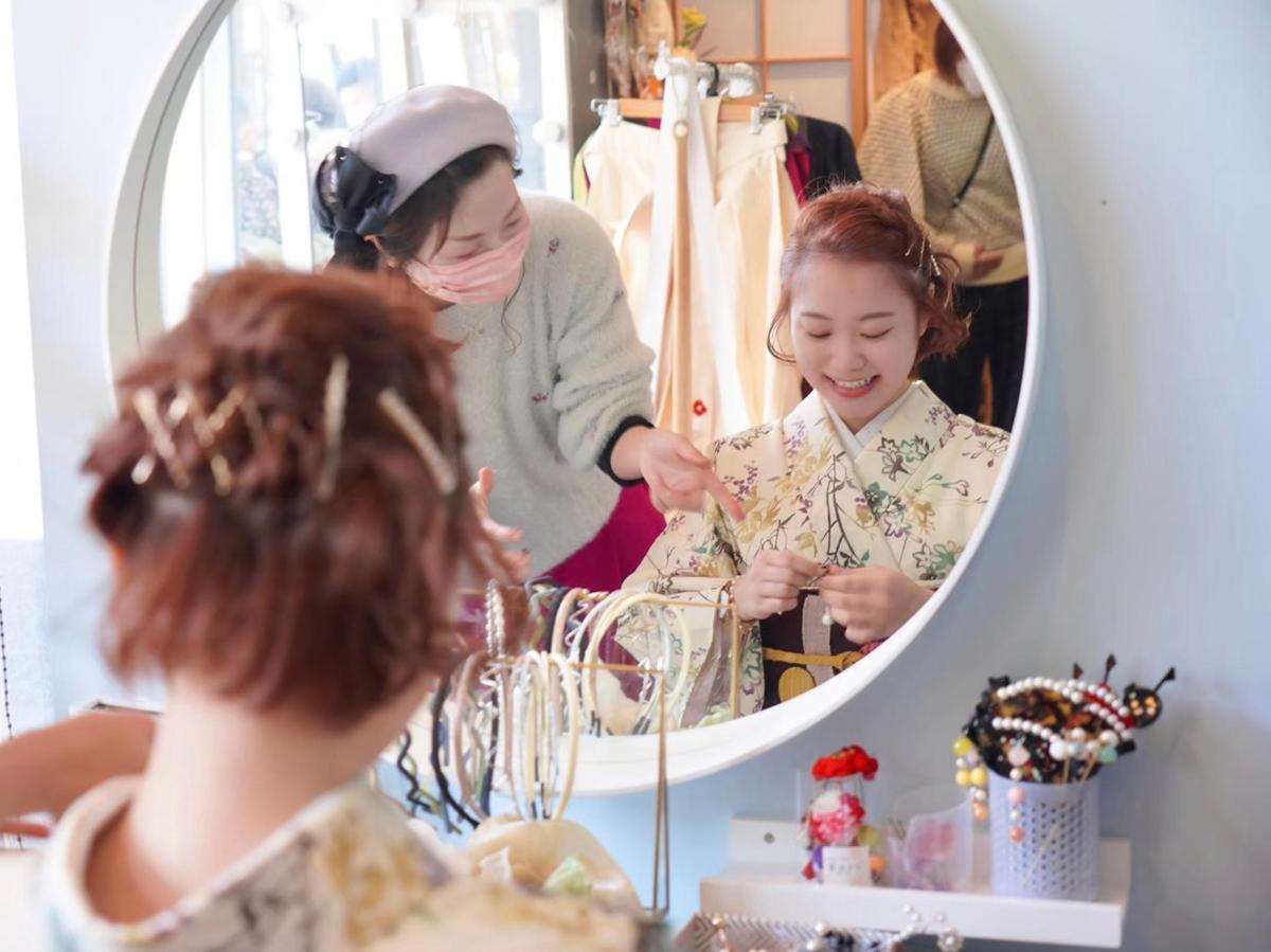a woman looking at a girl in front of a mirror