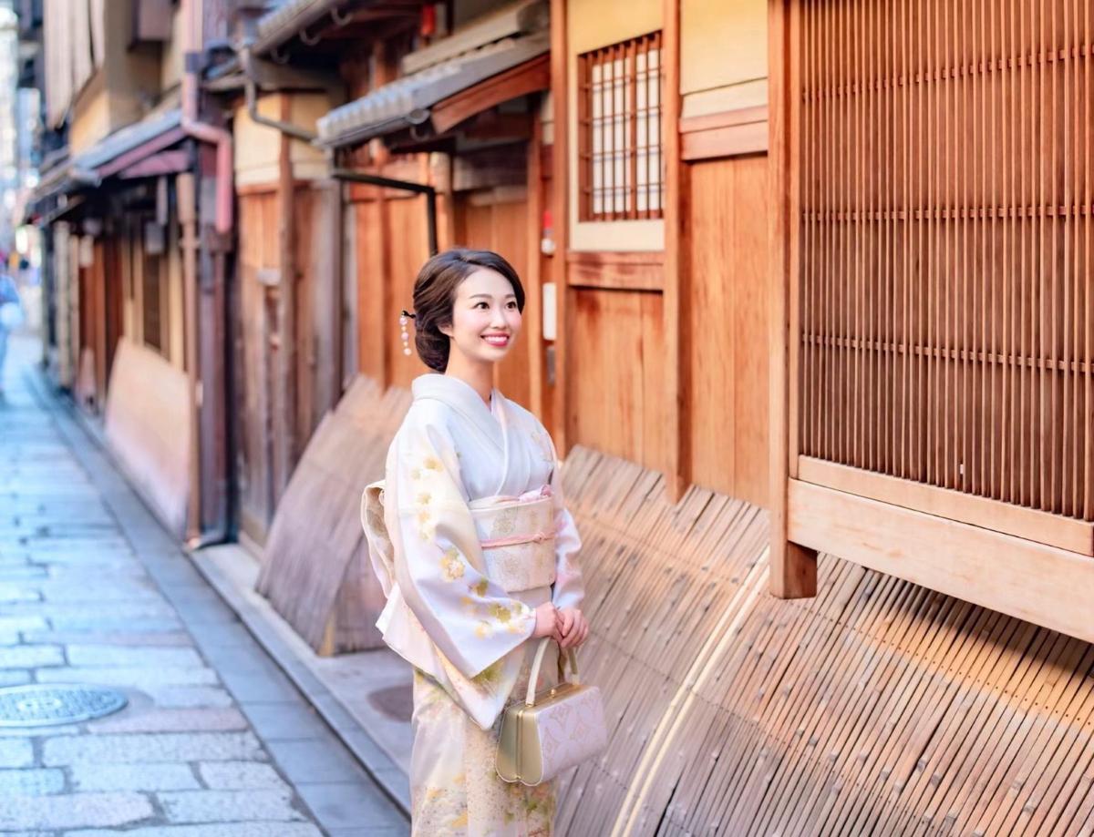 a woman in a kimono walking down a street
