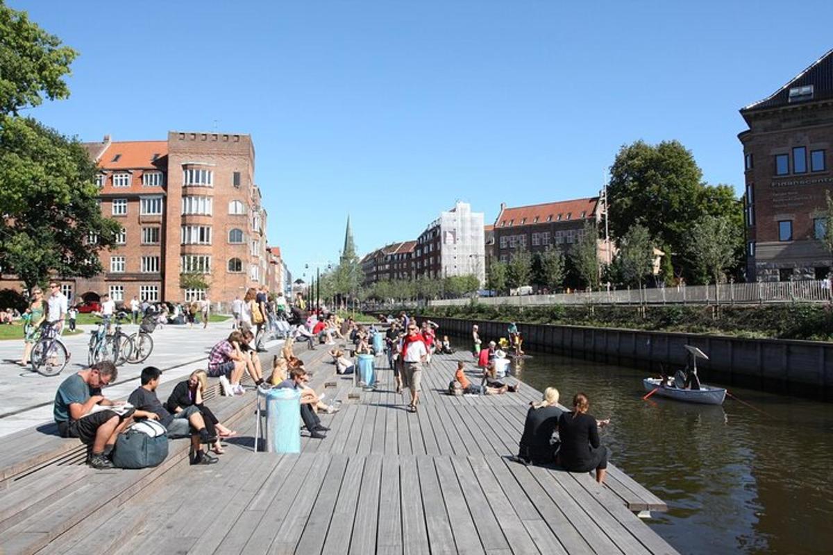 eine Gruppe von Menschen, die auf einem Dock neben einem Fluss sitzen