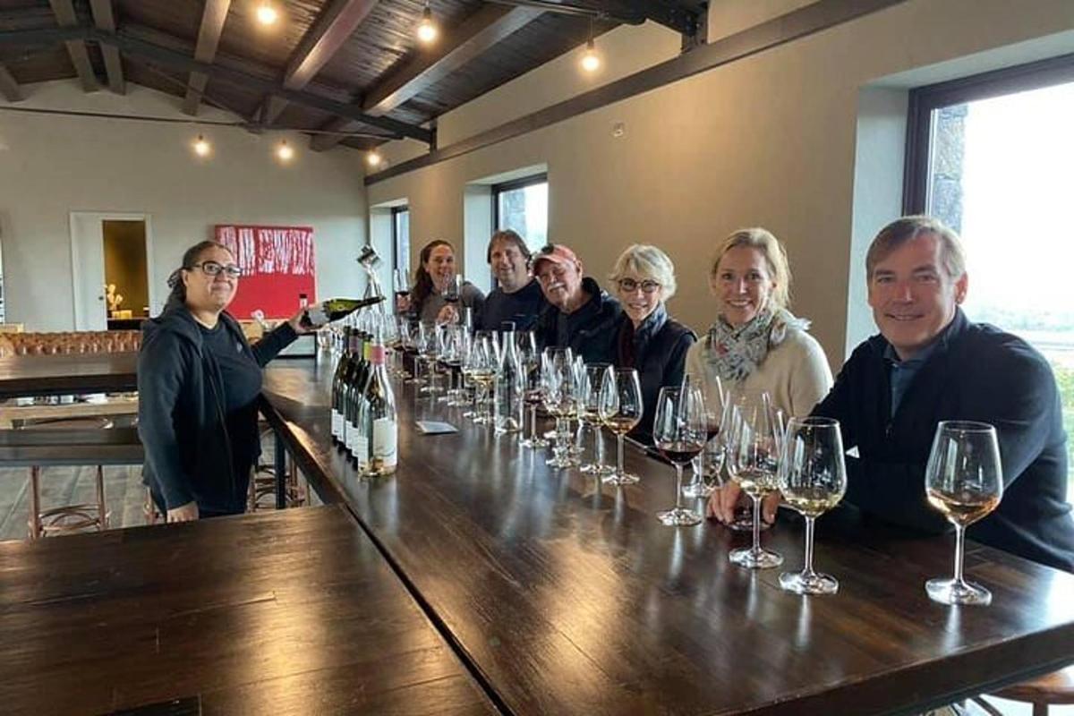 un grup de persones assegudes en un bar amb copes de vi
