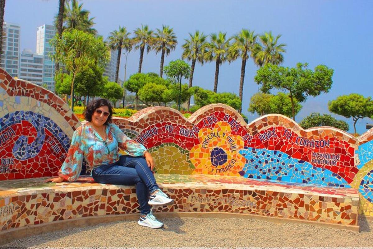 una donna seduta su una panchina ricoperta di mosaici